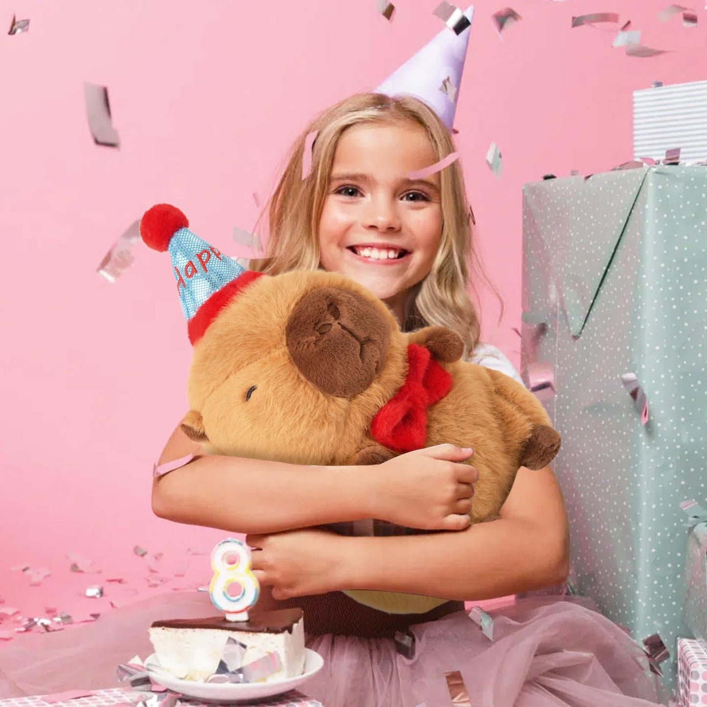 Girl smiling and hugging a capybara birthday plush pillow at a pink birthday party celebration