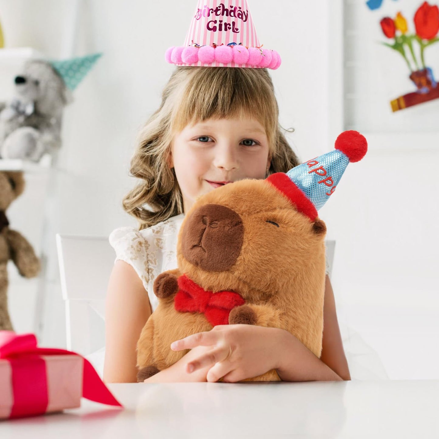 Girl holding Ditucu capybara birthday plush pillow wearing a party hat at birthday celebration