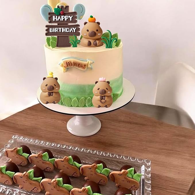 Cute capybara cake toppers on a birthday cake with Happy Birthday sign and nature-themed decorations