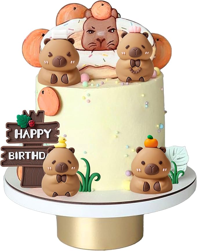 Birthday cake decorated with cute capybara cake toppers and a donut-shaped topper on white frosting