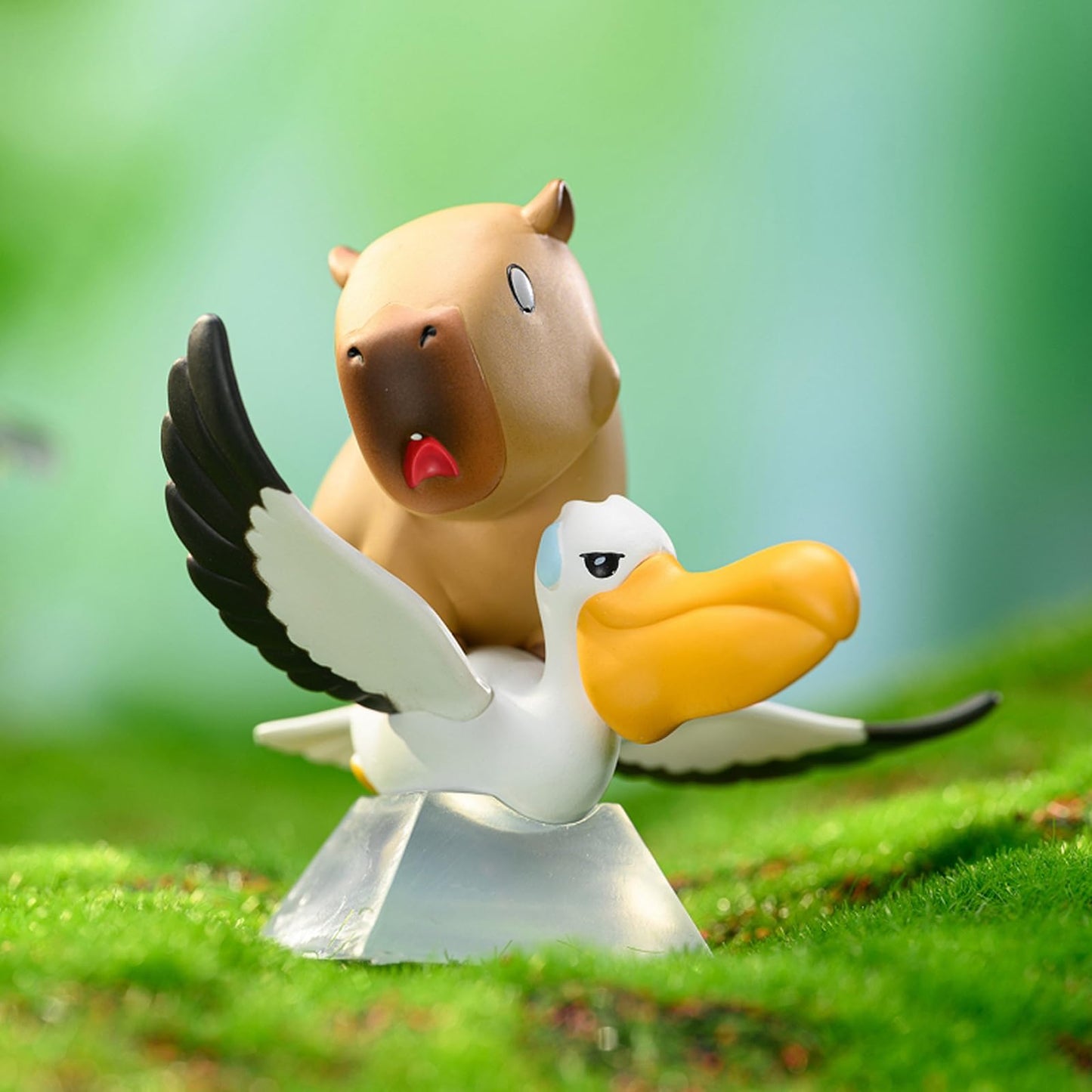Capybara Cute Cake Toppers with a playful capybara riding on a white bird figurine on green grass
