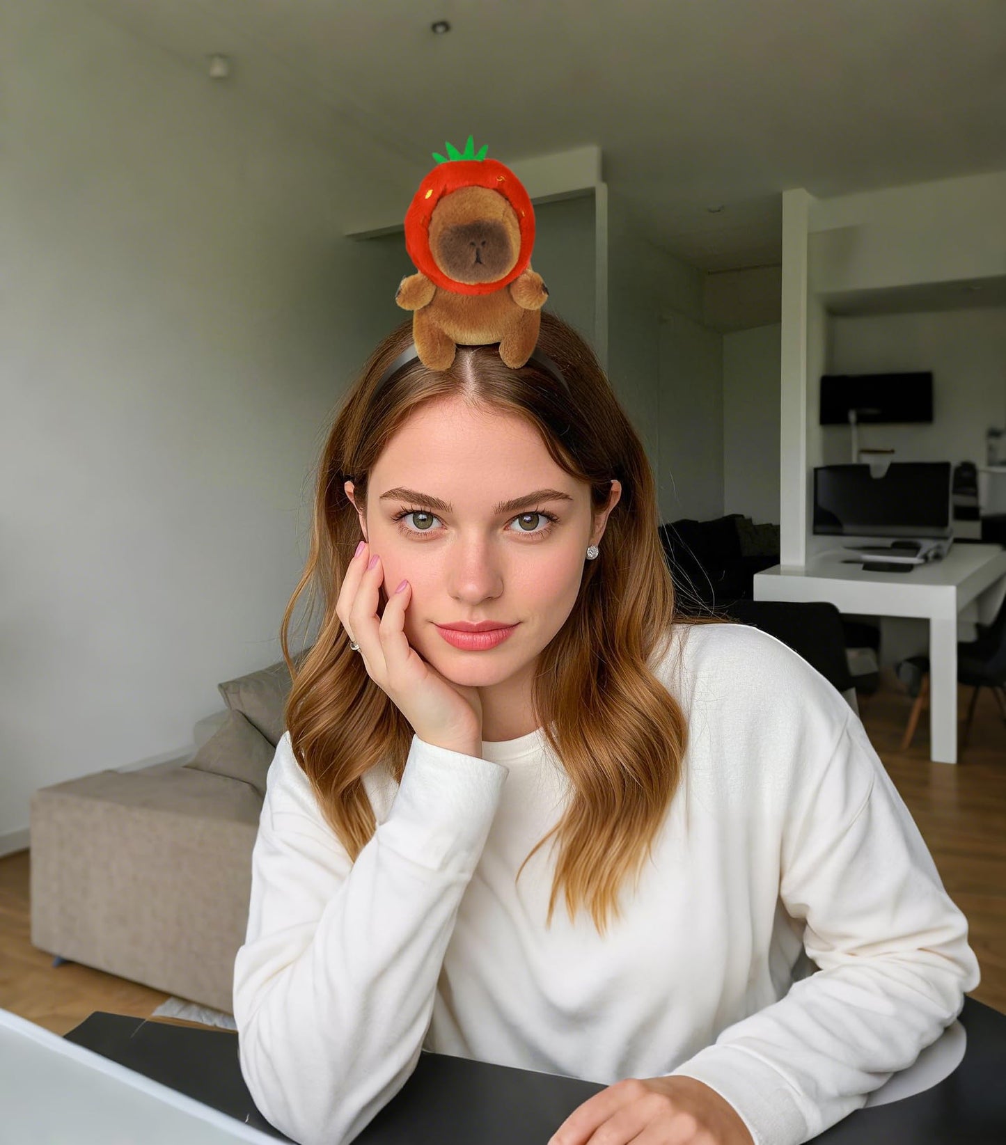 Woman wearing capybara headband accessory with plush capybara in a strawberry costume