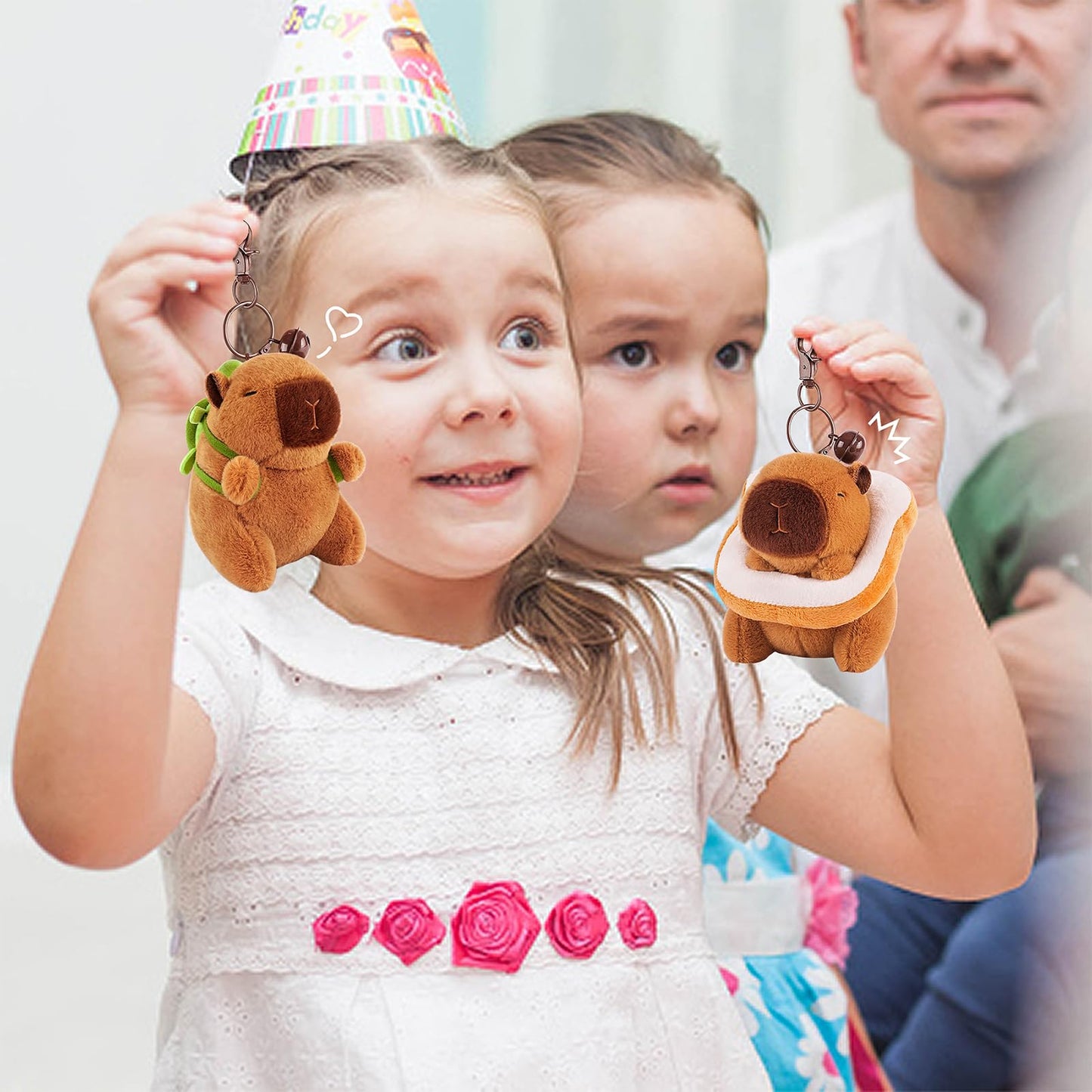 Two children holding Achwishap capybara keychain set plush toys at a birthday party