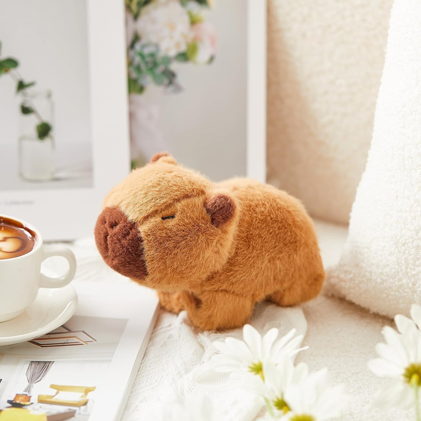 World plush capybara slap bracelet displayed near coffee cup and flowers on a cozy surface