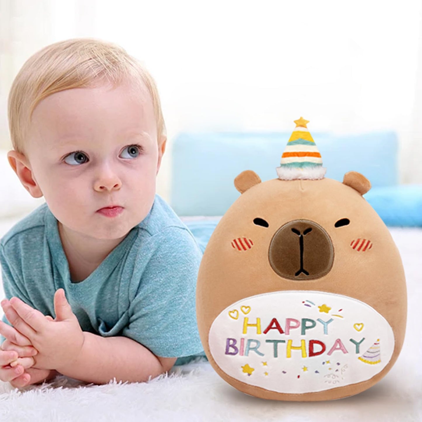cute capybara plush pillow with happy birthday design and party hat next to toddler