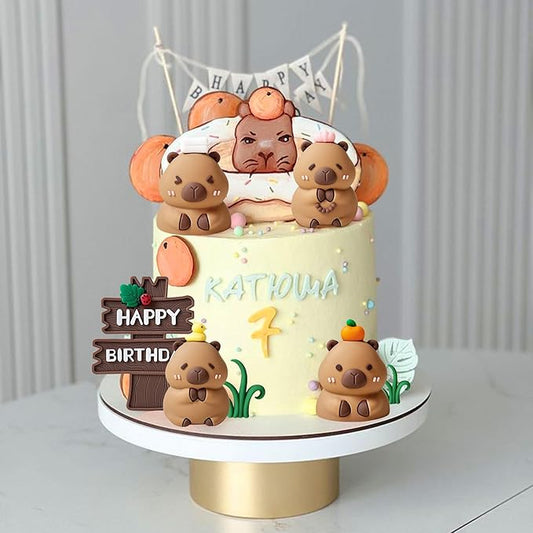 Birthday cake decorated with cute brown capybara cake toppers and colorful decorations on white stand