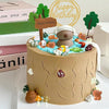 Capybara cake toppers set on a birthday cake with water, trees, and happy birthday sign decoration