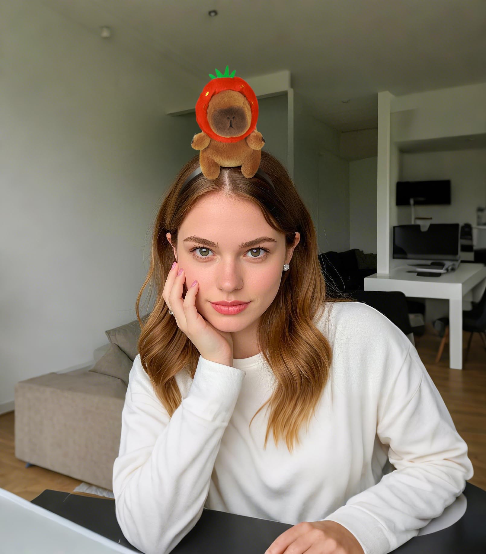 Woman wearing capybara headband accessory with plush capybara in a strawberry costume