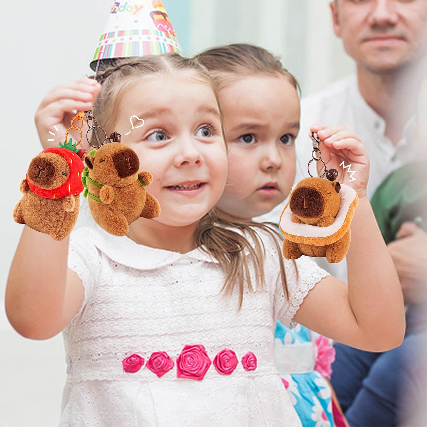 Girl holding capybara keychain set with cute plush designs dressed as strawberry and toast
