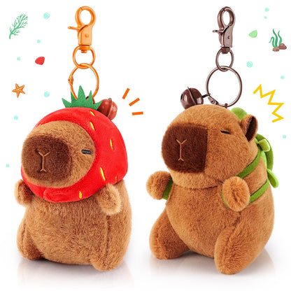 capybara keychain set with two plush keychains one wearing a strawberry hat and the other with a green backpack