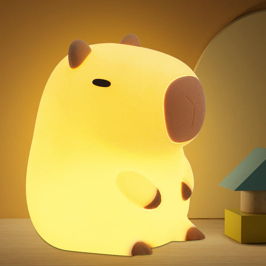 capybara night light glowing warmly on a wooden surface with a cozy background