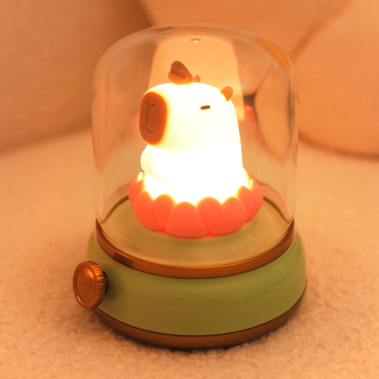 capybara night light with glowing animal figure inside glass dome and green base