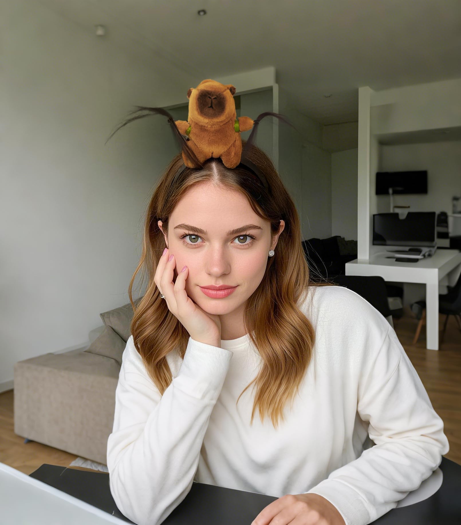 Young woman wearing a cute capybara hair accessory with plush design and feather details indoors